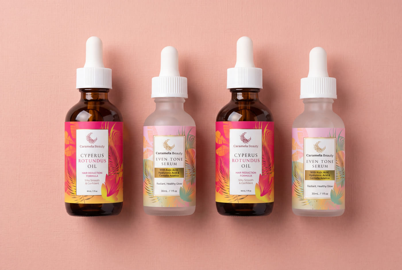 Caramela oil and Even Tone Serum bottles tiled on blush