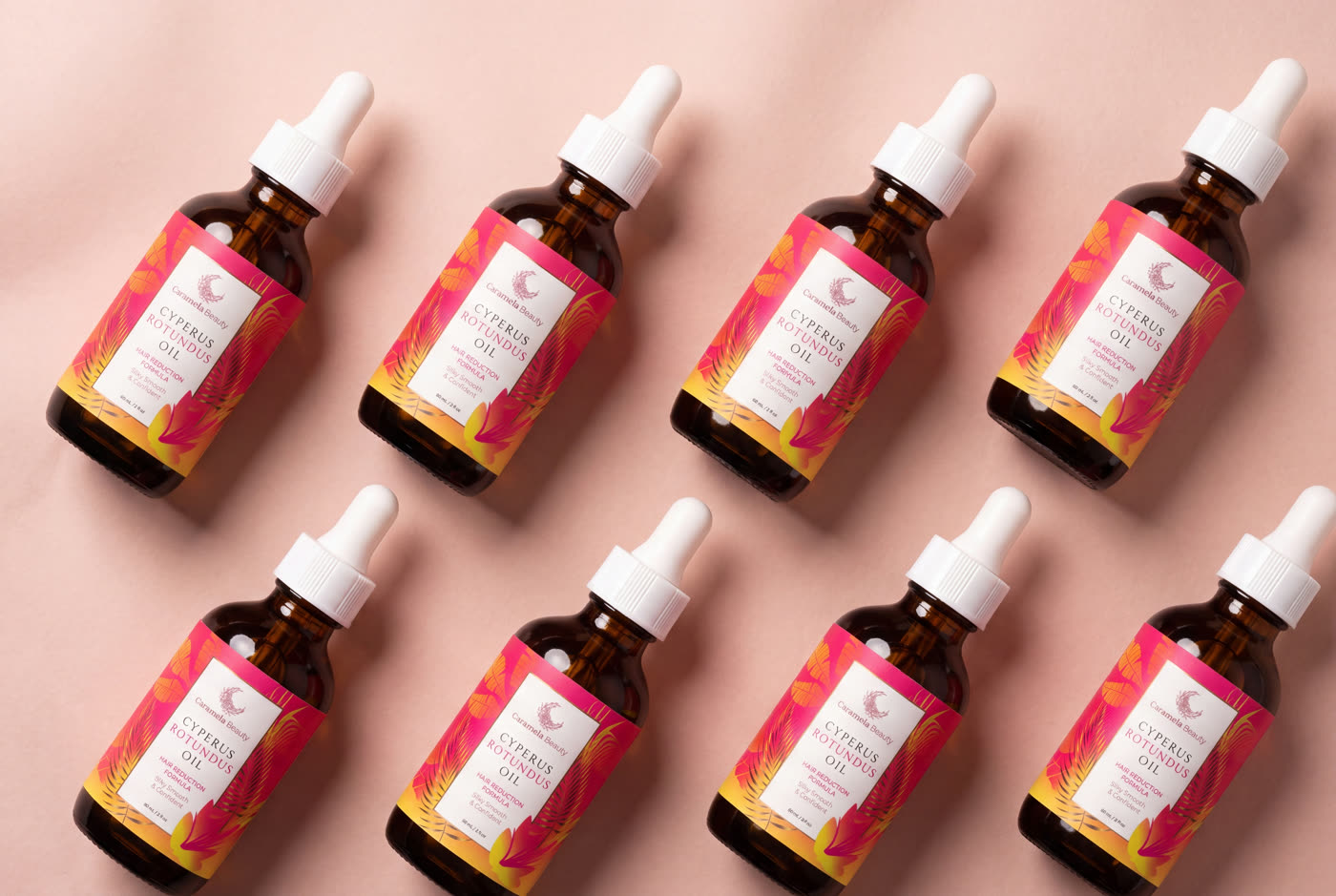 Five Caramela Cyperus Rotundus Oil bottles tiled on a blush background